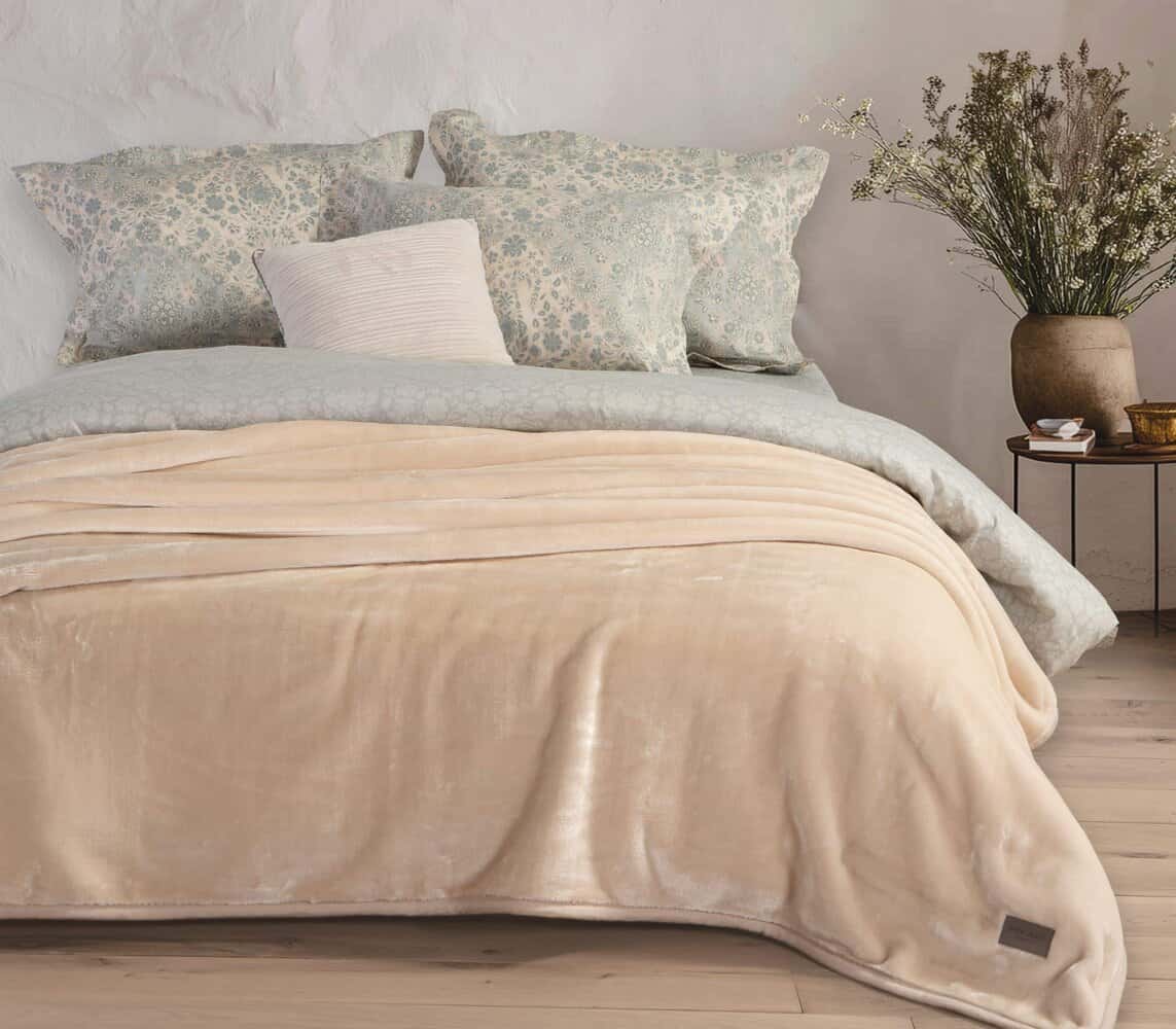 κουβέρτα βελουτέ εκρού στρωμένη σε κρεβάτι